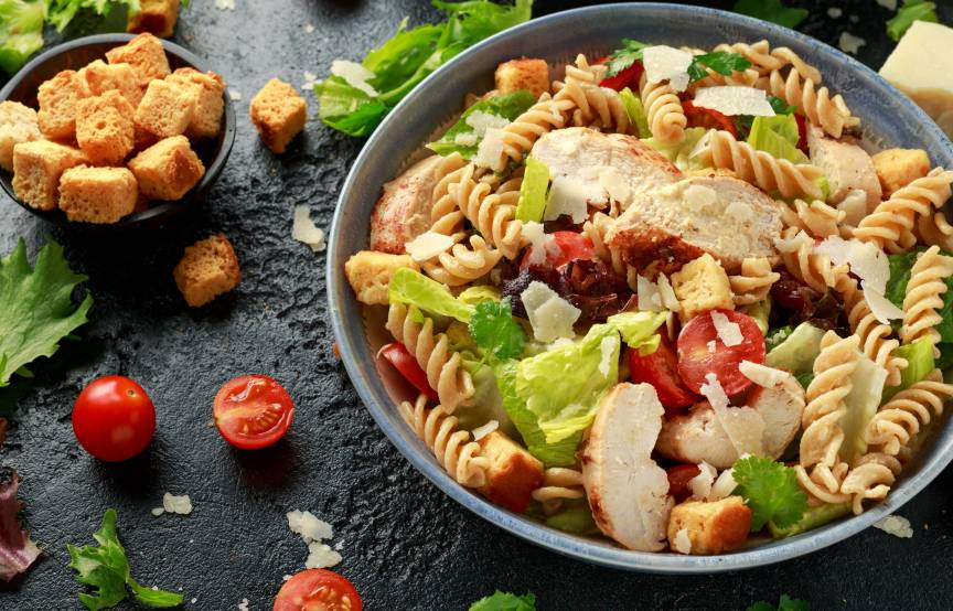 Salat aus Resten von Nudeln, Brot und Hähnchen angerichtet mit Cherrytomaten in einer Salatschüssel