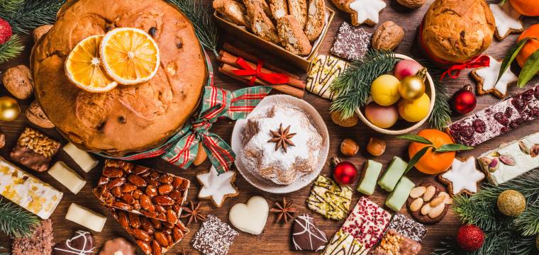 Verschiedene Weihnachtsplätzchen und Kuchen auf einem Holztisch in einer italienischen Küche