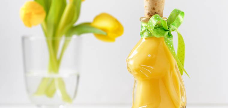 Selbst gemachter Eierlikör in einer Flasche in hasenform auf einem österlich dekorierten Tisch Selbst gemachter Eierlikör in einer Flasche in hasenform auf einem österlich dekorierten Tisch