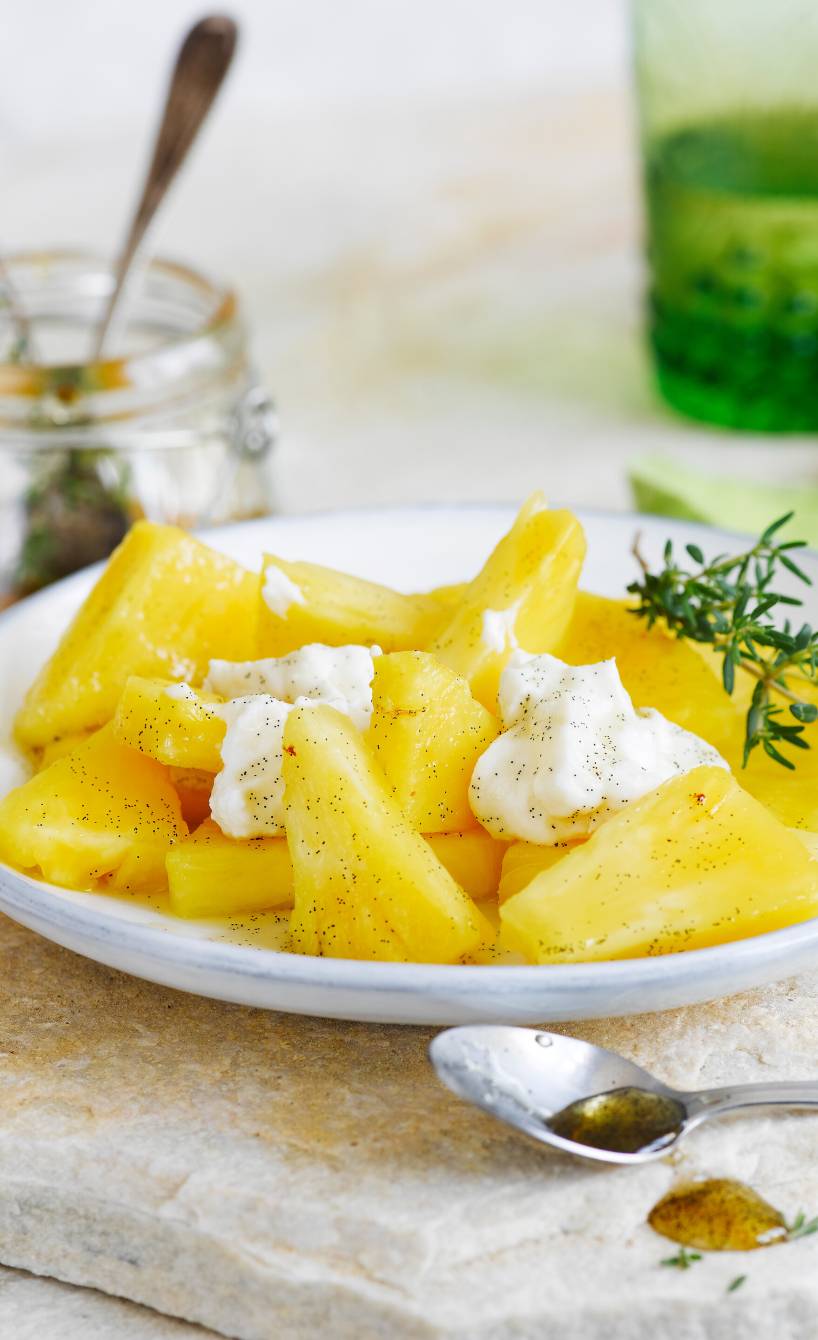 Ananas-Ricotta-Dessert angerichtet mit Thymian-Vanille-Honig auf einem Dessertteller