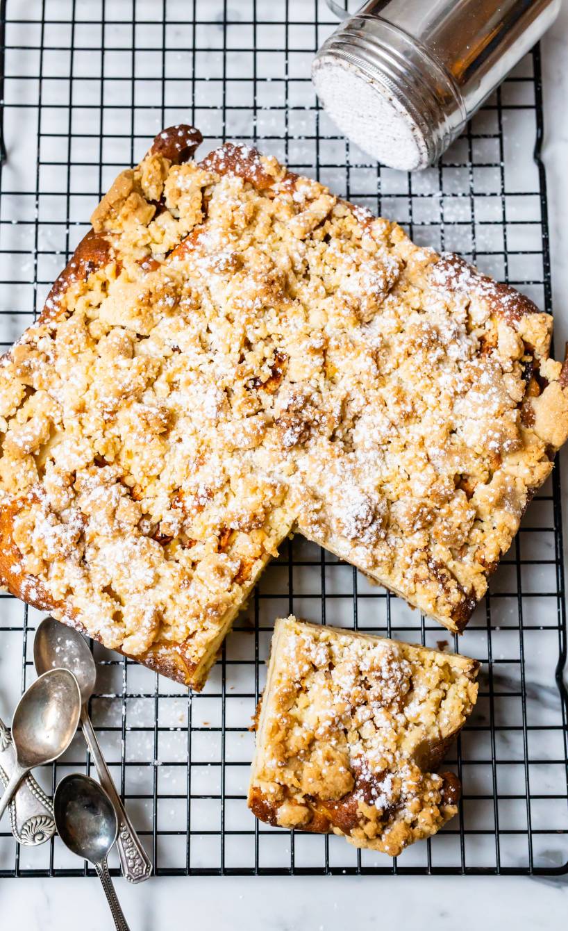 Apfelkuchen mit Zimtstreuseln vom Blech angeschnitten auf einem Kuchengitter