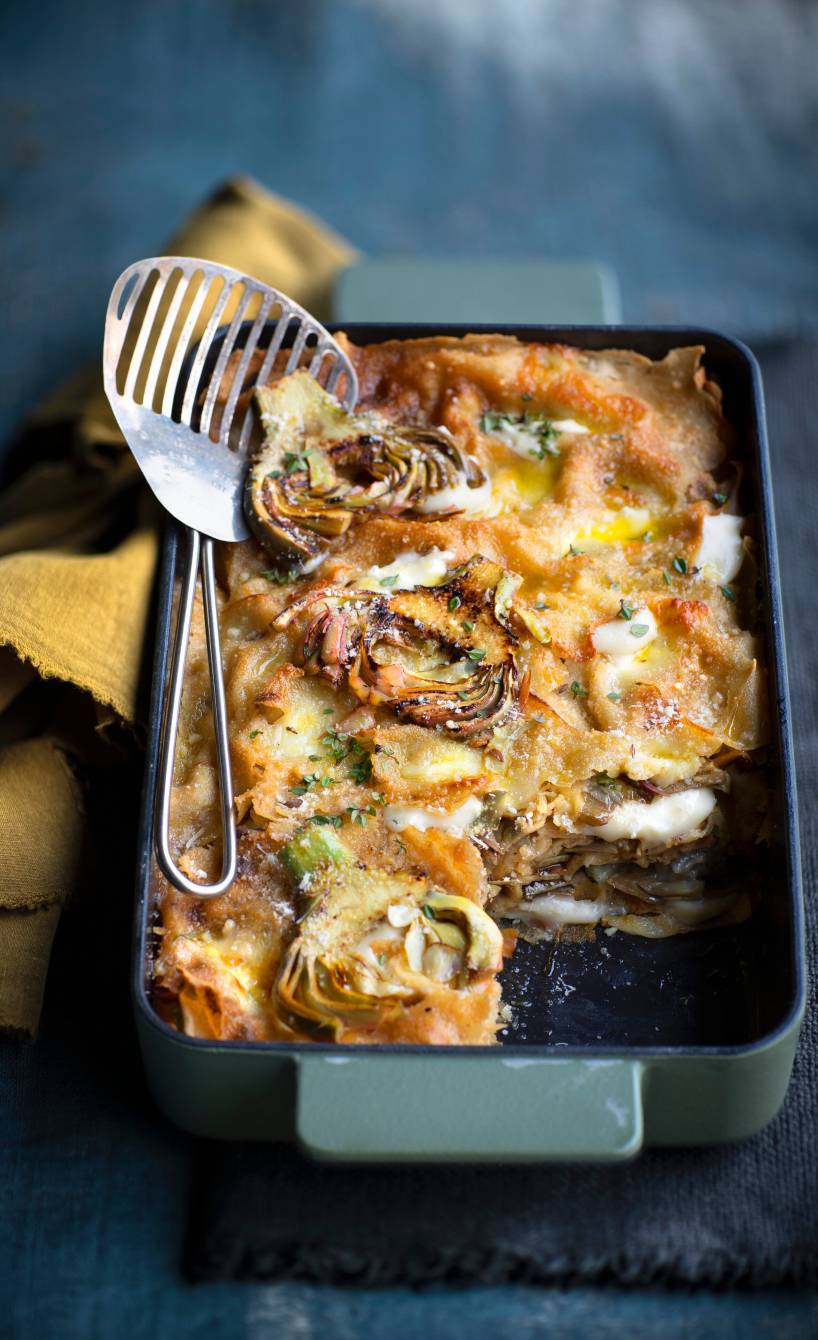 Überbackene Lasagne mit Artischocken und Frischkäse in einer Auflaufform auf einem Tisch