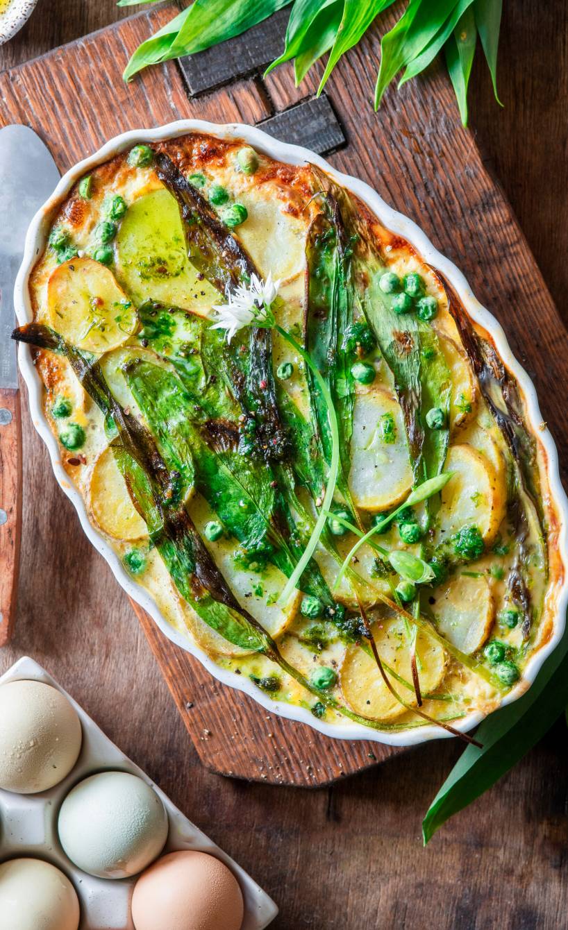Frittata mit Kartoffeln und Bärlauch in einer Auflaufform auf einem Holzbrett