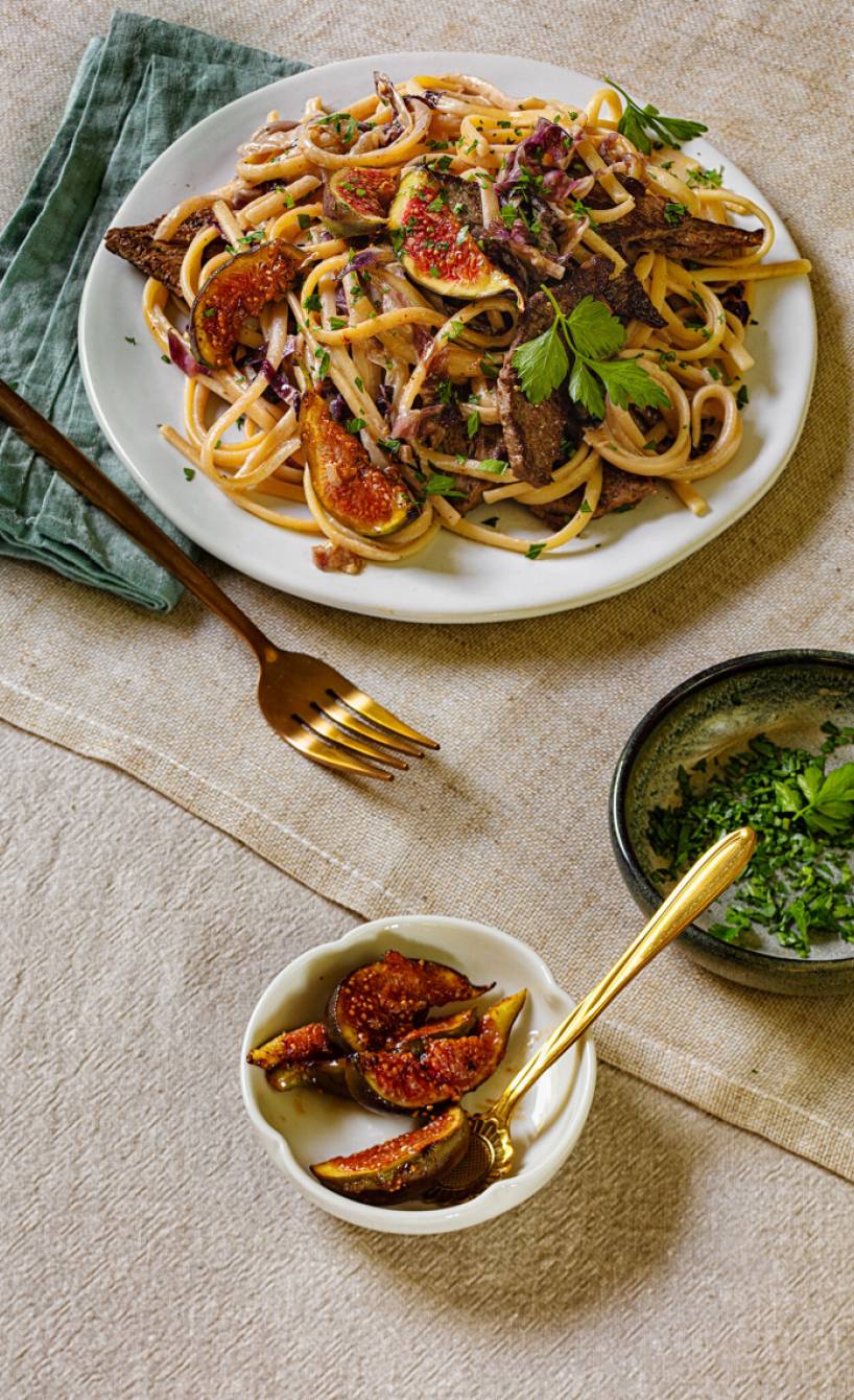 Bavette mit Rinderfiletstreifen und Gorgonzolasoße getoppt von frischen Feigen angerichtet auf einem Pastateller