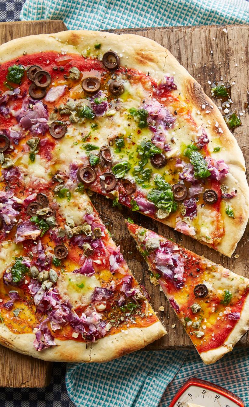Runde, angeschnittene Zwiebelpizza auf einem Holzbrett