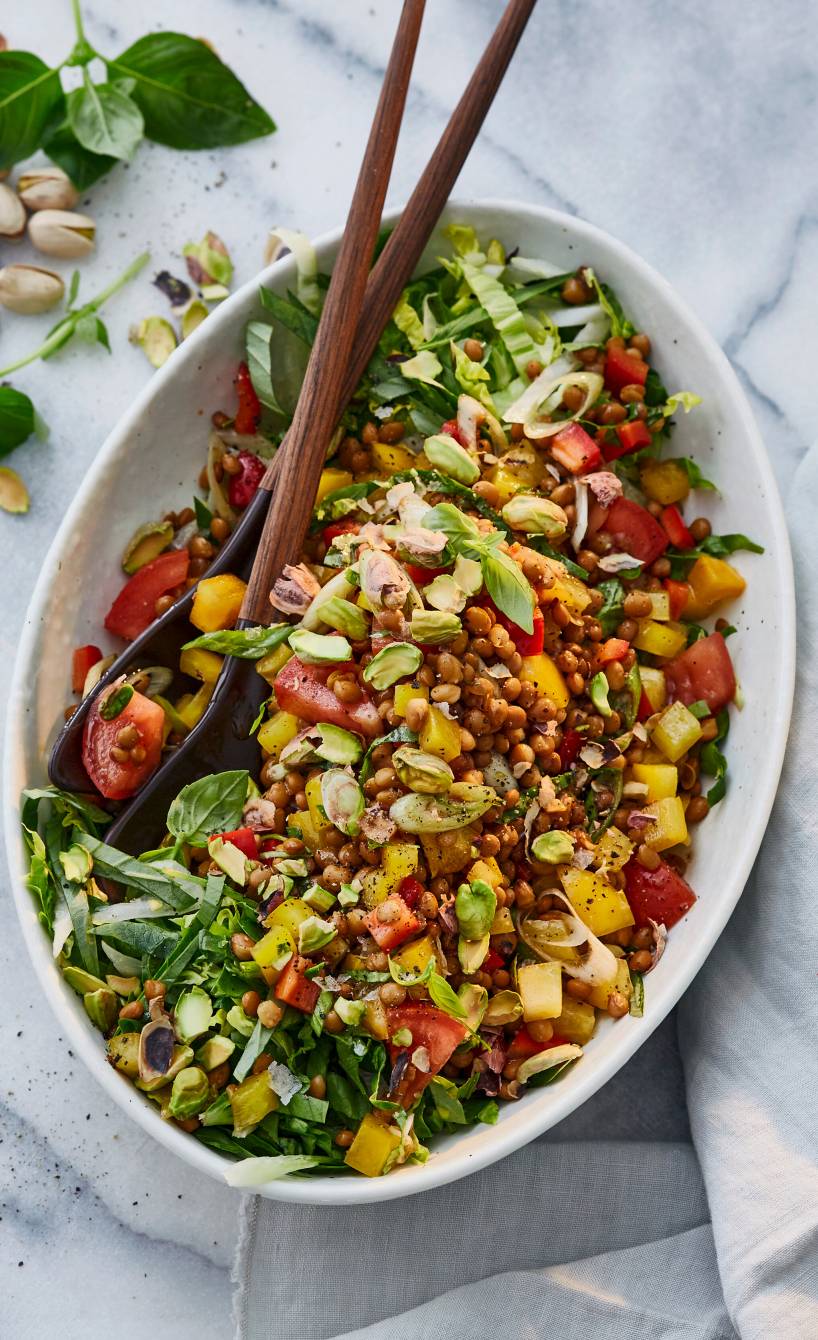 Veganer Balsamico-Linsensalat getoppt mit Pistazien in einer Salatschüssel auf einem Tisch