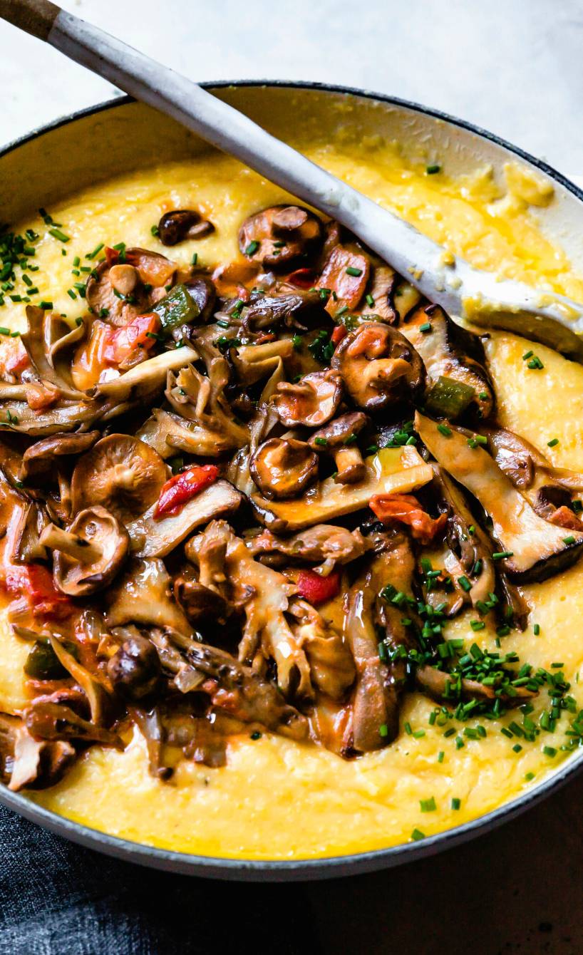 Polenta in einem Topf getoppt mit vielen Pilzen