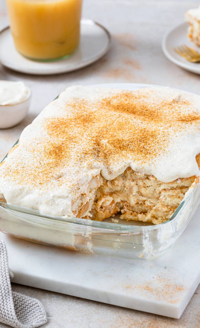 Apfeltiramisu mit Mascarpone und Löffelbiskuit angeschnitten in einer Auflaufform und mit Zimtzucker bestreut