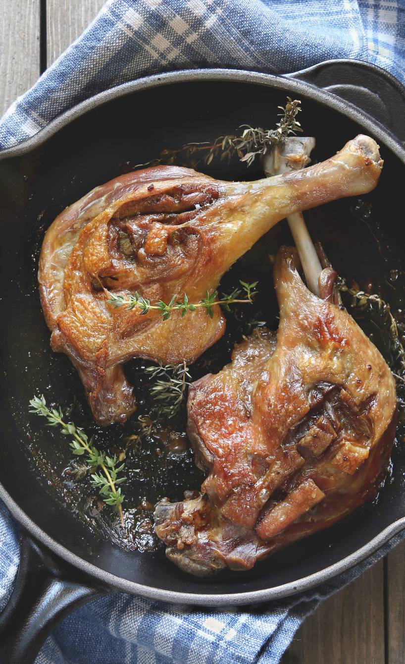 Zwei Entenkeulen in einer Pfanne garniert mit Thymian