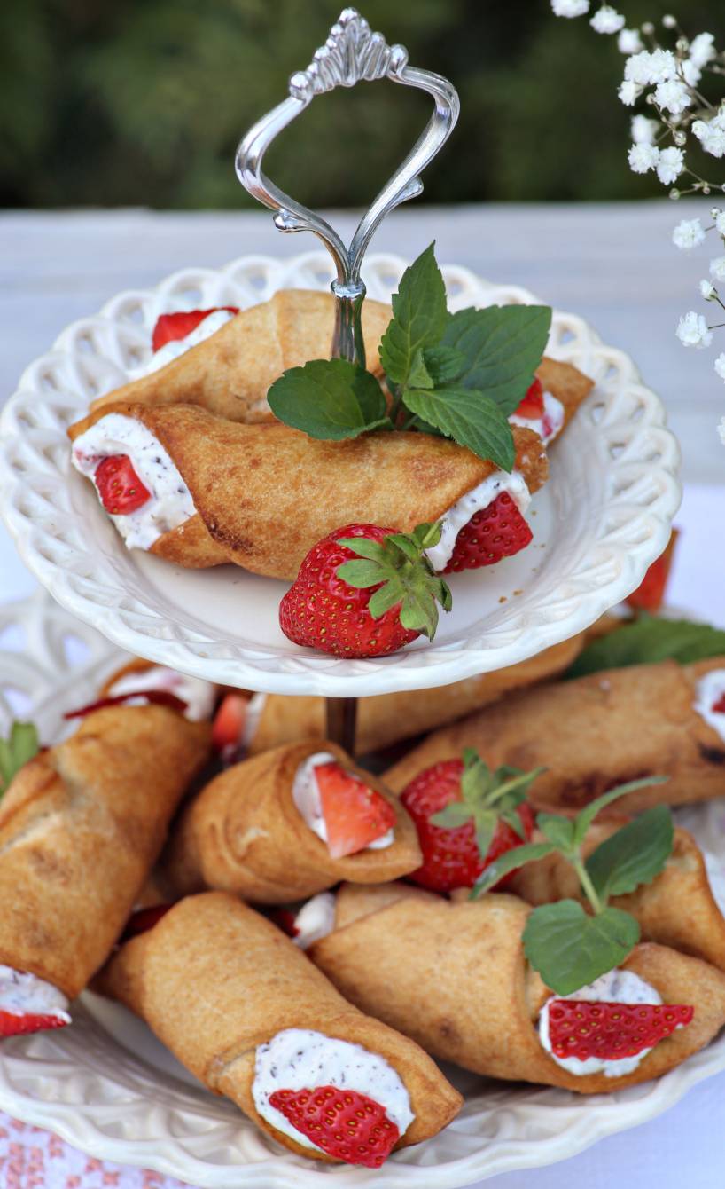 Cannoli mit Ricotta-Stracciatella-Füllung und frischen Erdbeeren auf einer Etagere