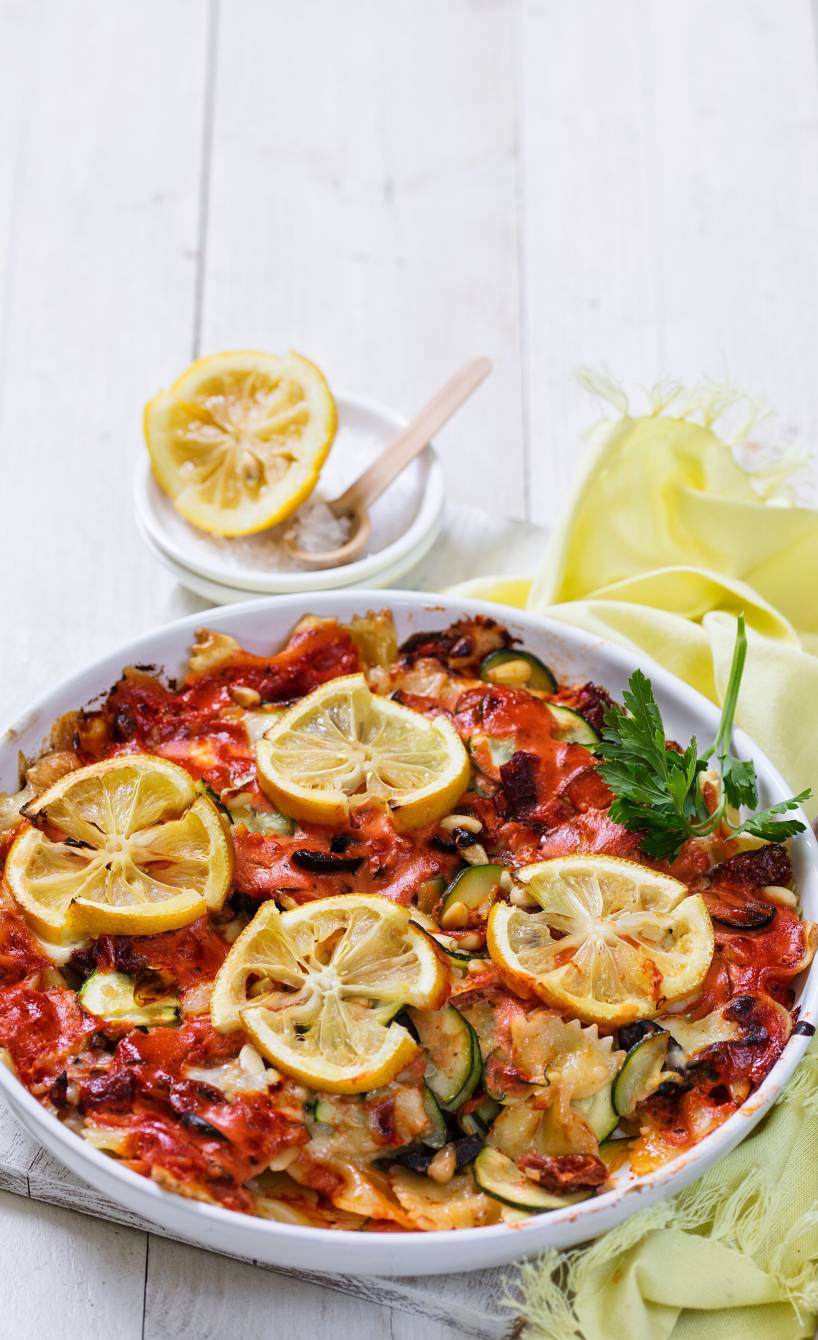 Nudelauflauf mit Zucchini garniert mit Salzzitronenscheiben auf einem Tisch