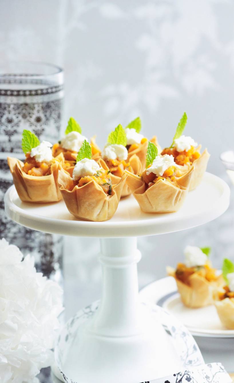 Mehrerer selbstgebackene Filoteig-Törtchen gefült mit Süßkartoffeln, Ziegenfrischkäse und Honig getoppt von Minzblättern auf einer Etagere