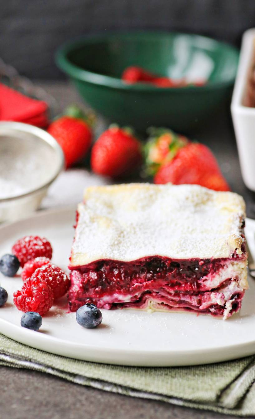 Ein Stück süße Lasagne mit Beerenschichten auf einem Dessertteller