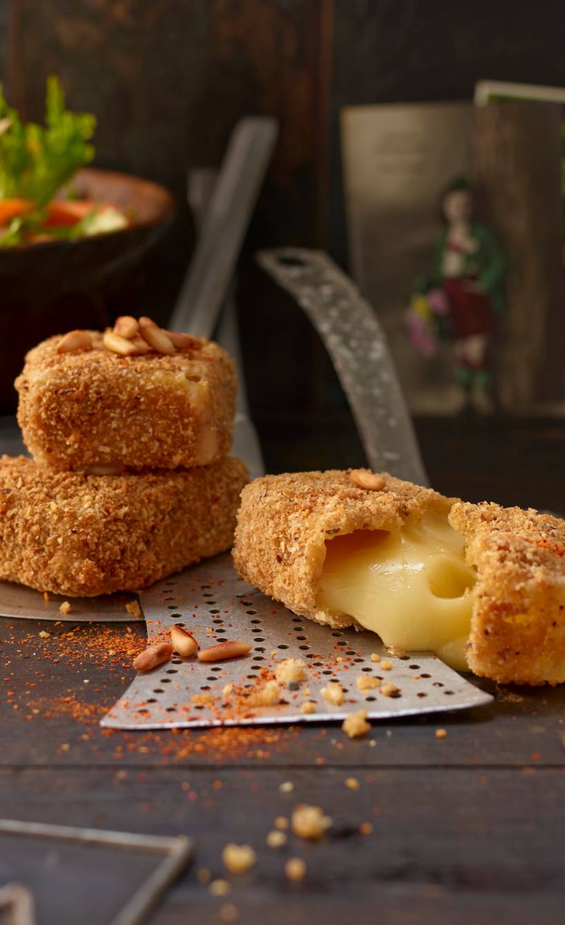 Backkäse-Nuggets auf einem Teller, einer durchbrochen mit herausfließendem Käse