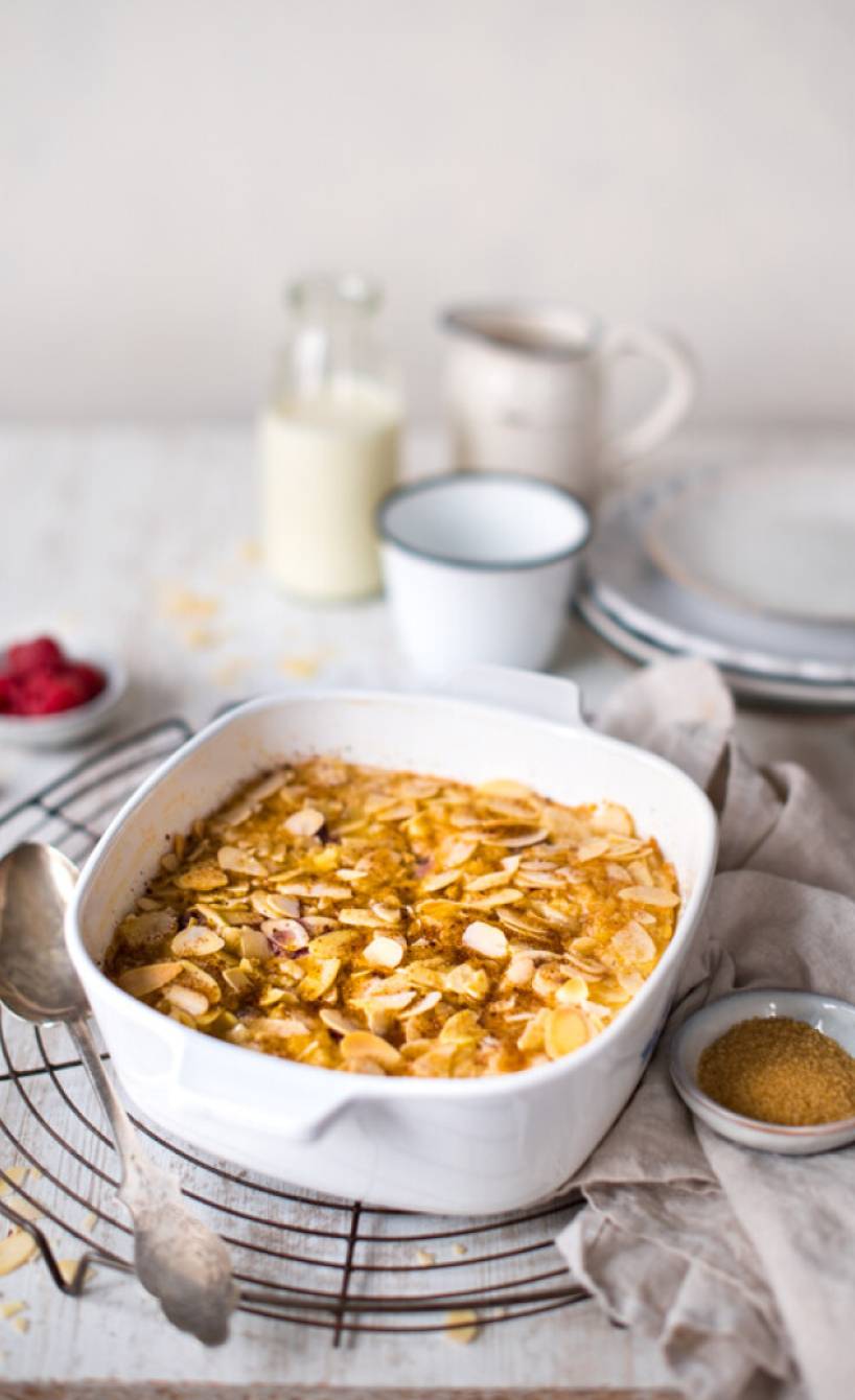 Süßes Risotto mit Himbeeren in einer Auflaufform getoppt mit Mandelblättchen auf einem Kuchengitter