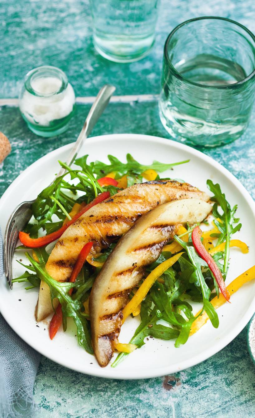 Veganer Rucola-Paprikasalatmit getoppt mit gegrillter Melone angerichtet auf einem Teller