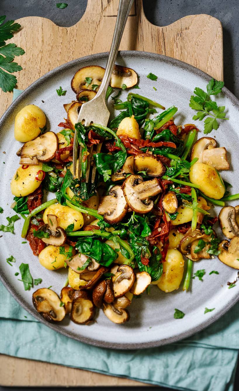 Gnocchipfanne mit Champignons und Babyspinat auf einem Teller