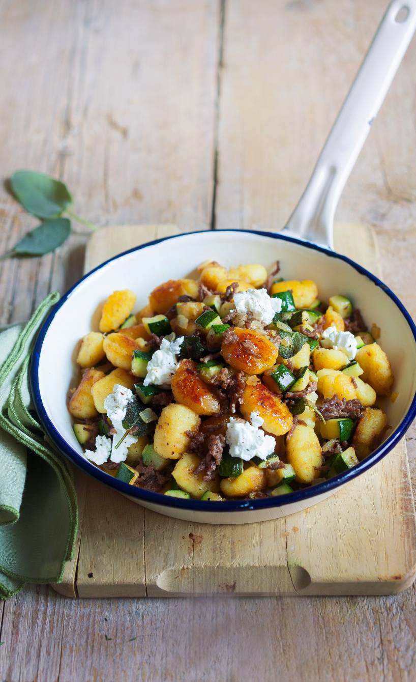 Gnocchi-Pfanne mit Hackfleisch in einer Pfanne auf einem Tisch, getoppt von Feta und Salbei daneben