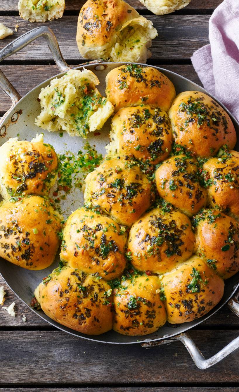 Hefebrötchen-Sonne mit selbst gemachter Bärlauchbutter in einer ofenfesten Pfanne auf einem Holztsich