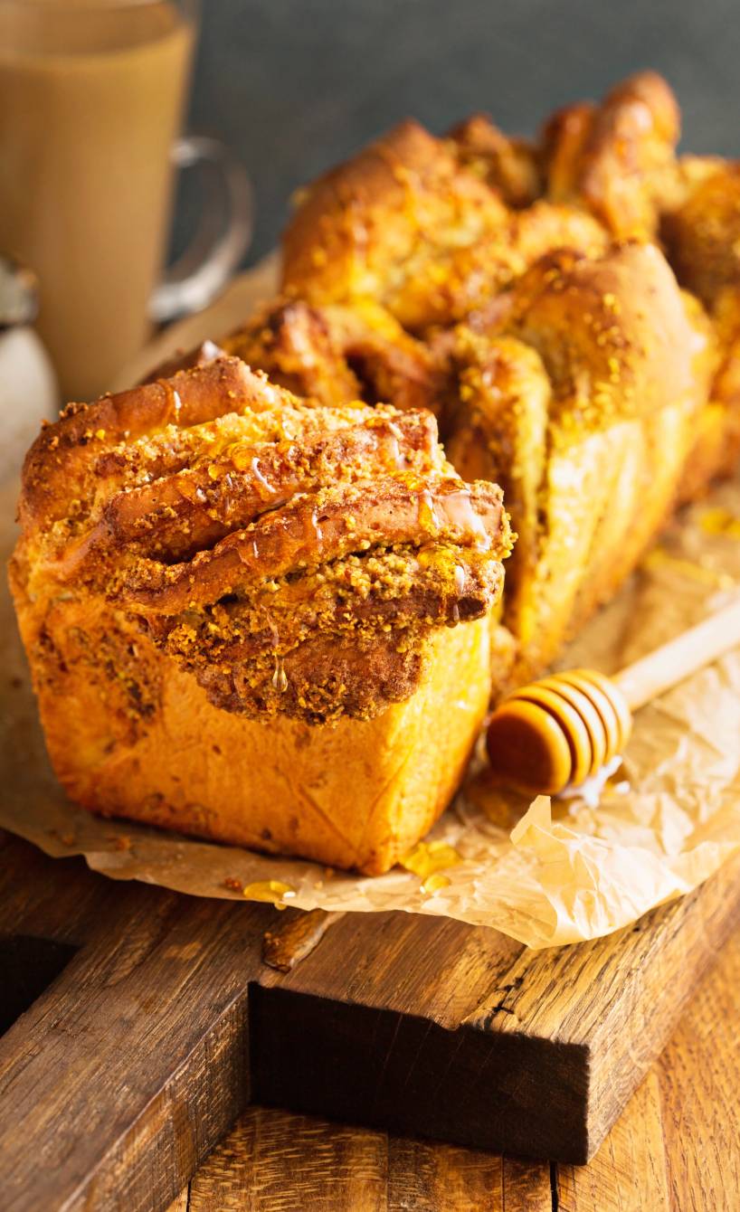 Angeschnittener Hefekuchen mit Walnuss-Pistazien-Füllung auf einem Holzbrett