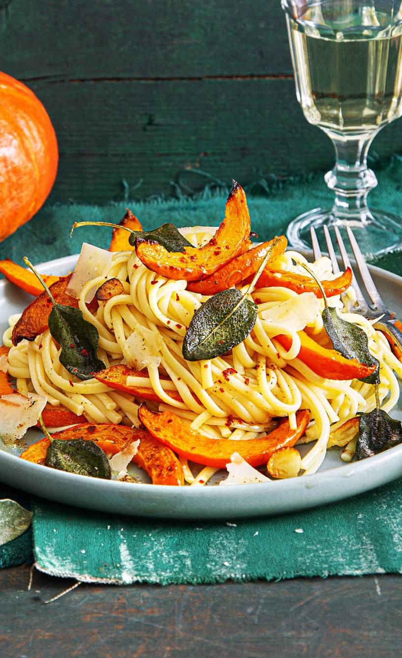 Linguine auf einem Teller getoppt vom Kürbisspalten