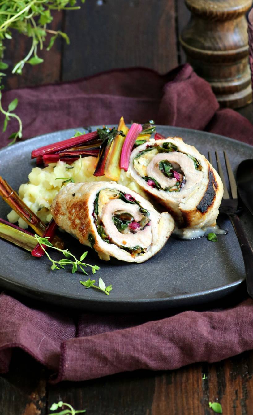 Zwei Schweine-Involtini mit Mangold-Taleggio-Füllung und Kartoffel-Pastinaken-Püree auf einem Teller