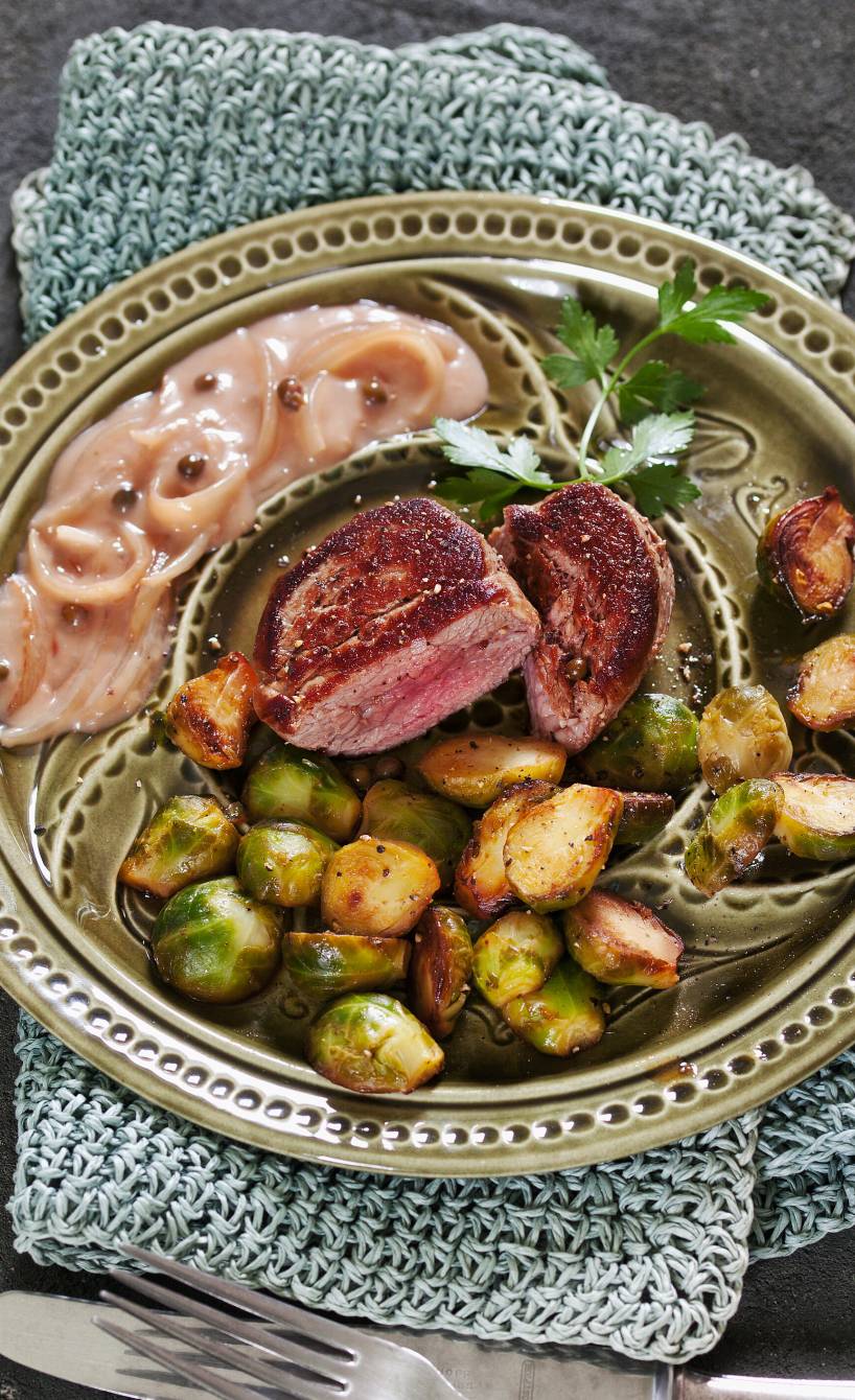 Kalbsmedaillons in der Mitte eines Tellers, drumherum gebratener Rosenkohl