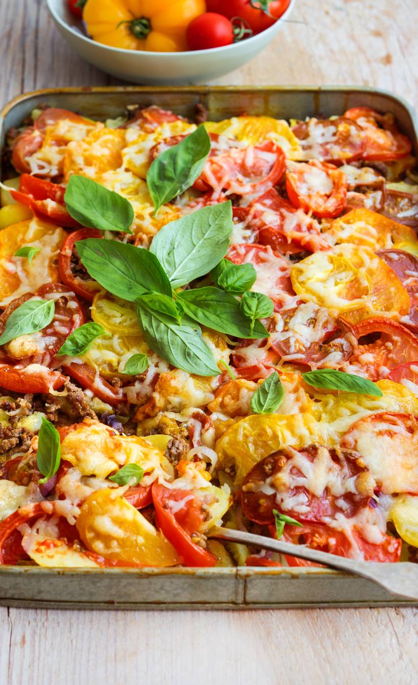 Kartoffelauflauf auf einem Backblech mit Tomaten, Hackfleisch und Käse überbacken
