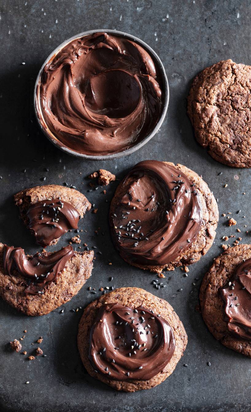 Chocolate Cookies mit Schokoladen-Ganache bestrichen und getoppt mit schwarzem Sesam auf einem Plätzchenteller