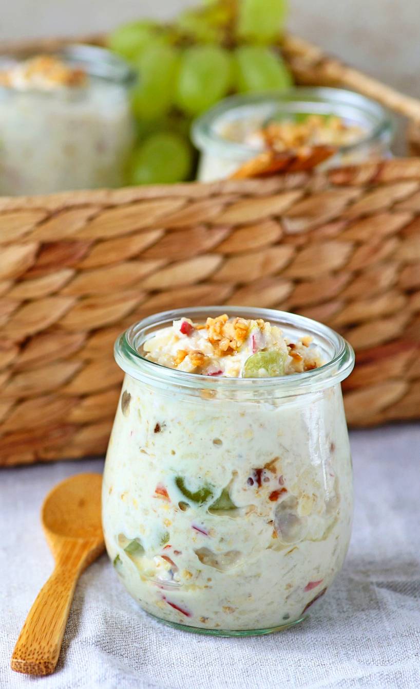 Mehrere Gläser mit selbstgemachtem Frucht-Müsli mit Joghurt getoppt von Haselnusskrokant auf einem Frühstückstisch