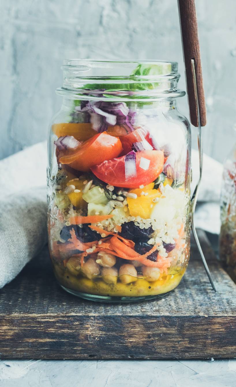 Bunter Quinoa-Salat mit Kichererbsen aus geschichteten Zutaten in einem Schraubglas