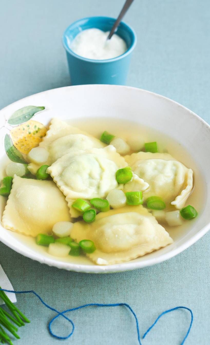 Klare Spargelsuppe mit einer Einlage aus selbstgemachten Bärlauch-Teigtaschen in einem tiefen Teller