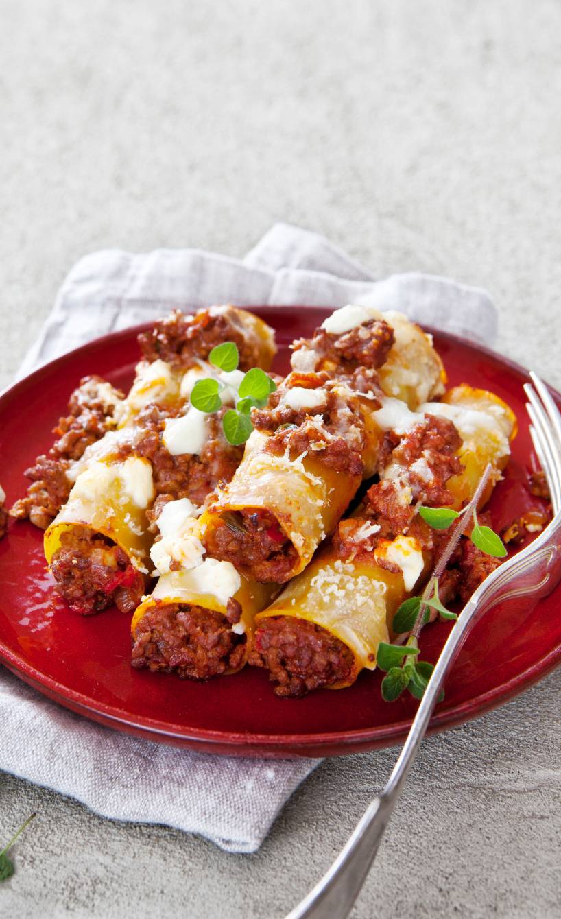 Mit Hackfleisch gefüllte Cannelloni gestapelt auf einem Teller