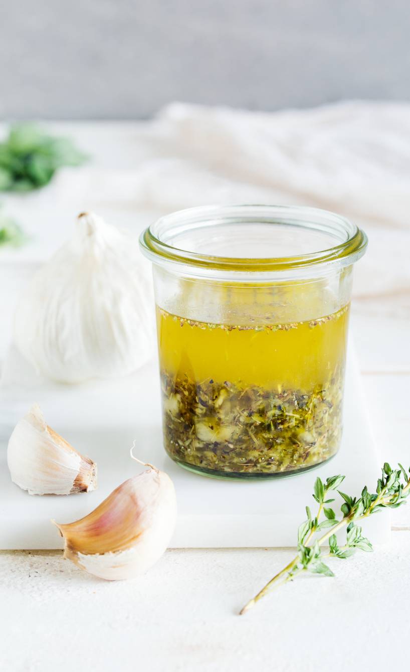 Selbstgemachte Knoblauch-Marinade in einem Weckglas auf einem Holztisch