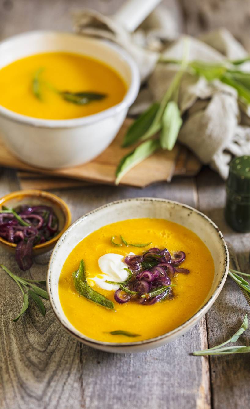 Selbstgekochte Kürbissuppe getoppt mit karamellisiertem Salbei, roten Zwiebelringen und Ziegenfrischkäse-Creme