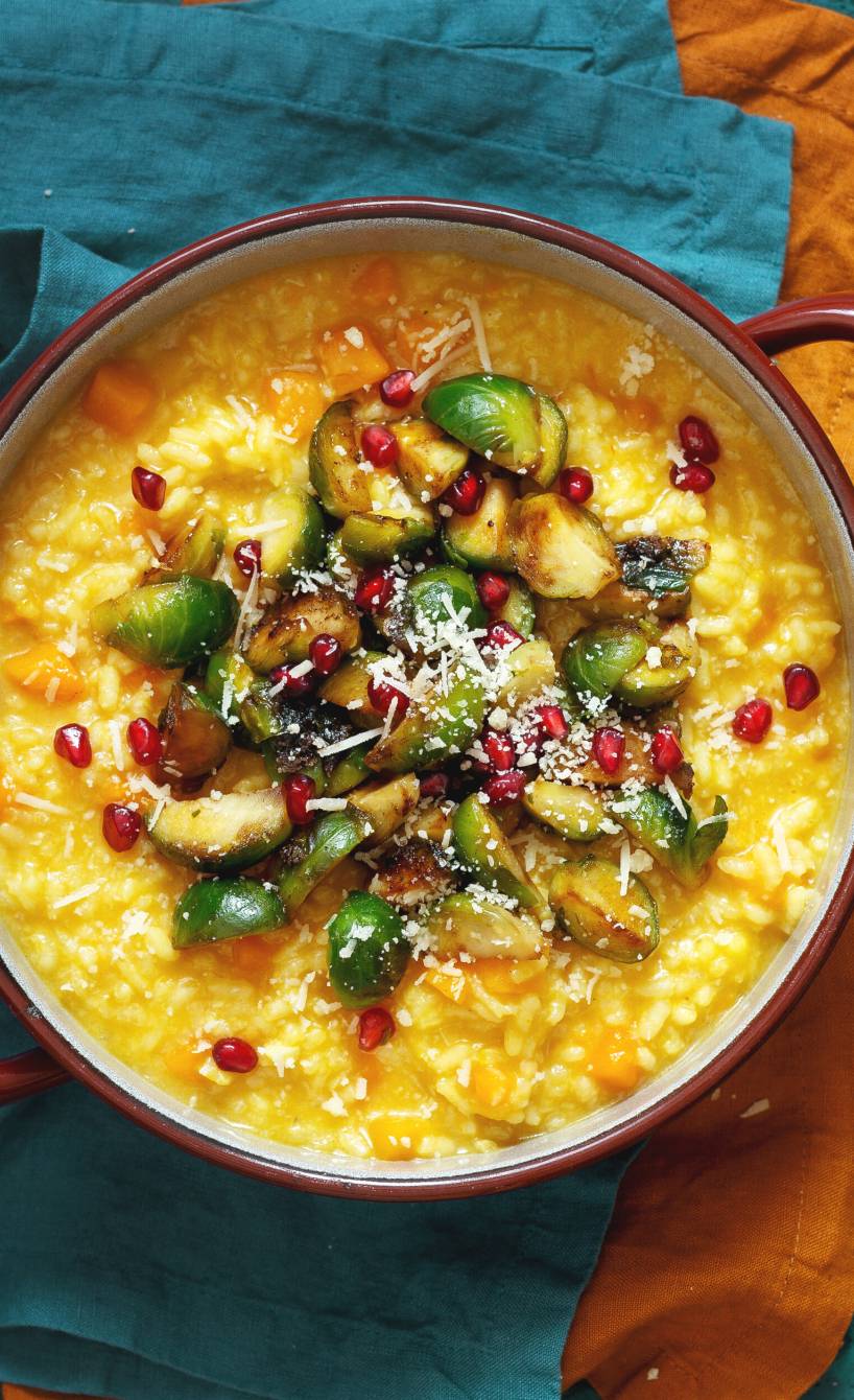 Safranrisotto in einem Topf getoppt mit karamellisiertem Rosenkohl, Parmesan und Granatapfelkernen