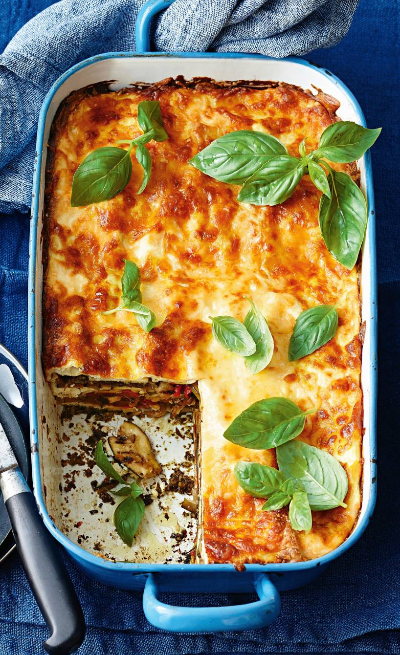 Lasagne mit Grillgemüse, Ricotta und grünem Pesto angeschnitten in einer Auflaufform von oben auf einem Tisch