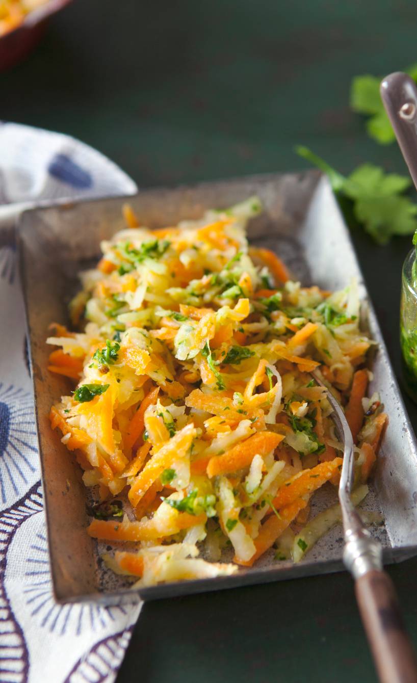 Lauwarmer Karotten-Kohlrabisalat angerichtet auf einem Teller, daneben Petersilienpesto in einem Glas