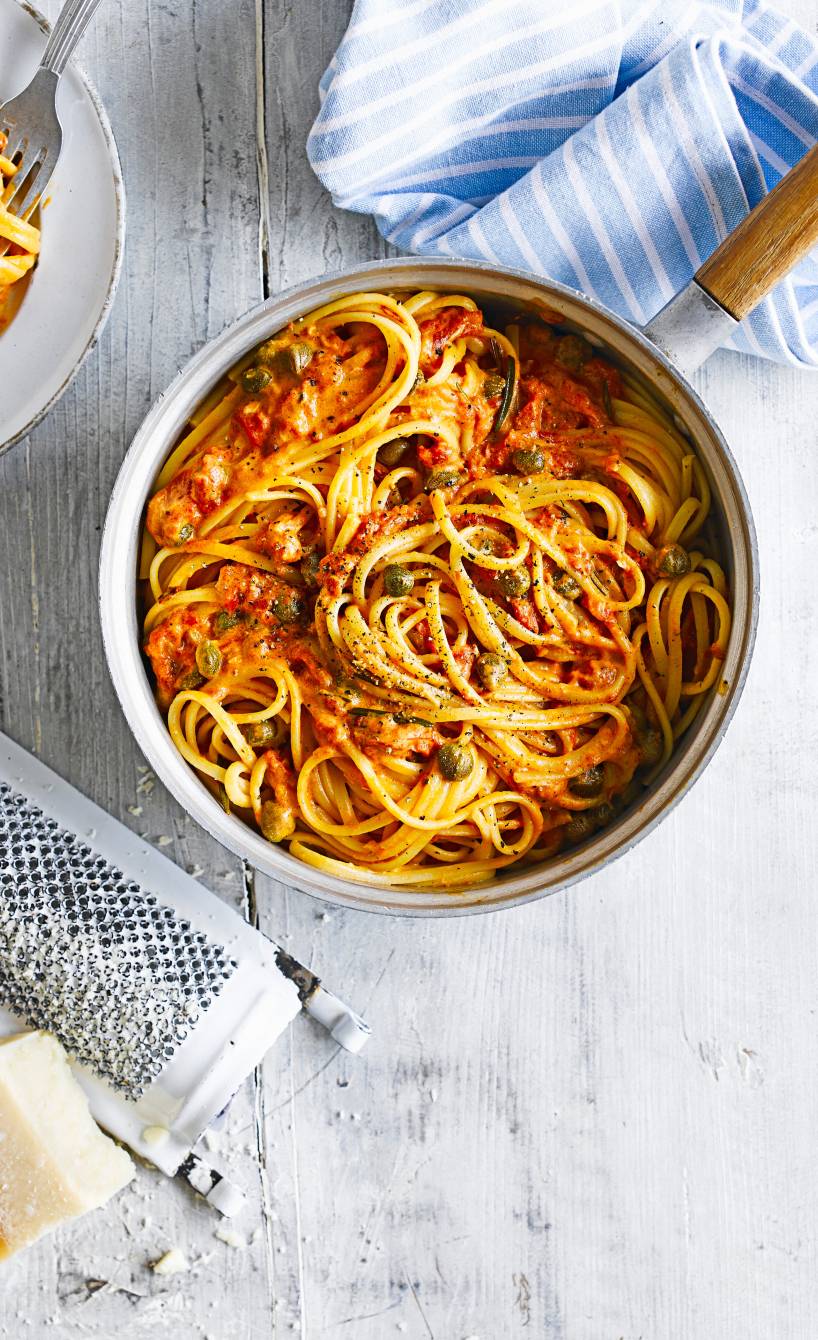 Linguine in Tomaten-Sahne-Soße mit Kapern angerichtet auf einem Pastateller