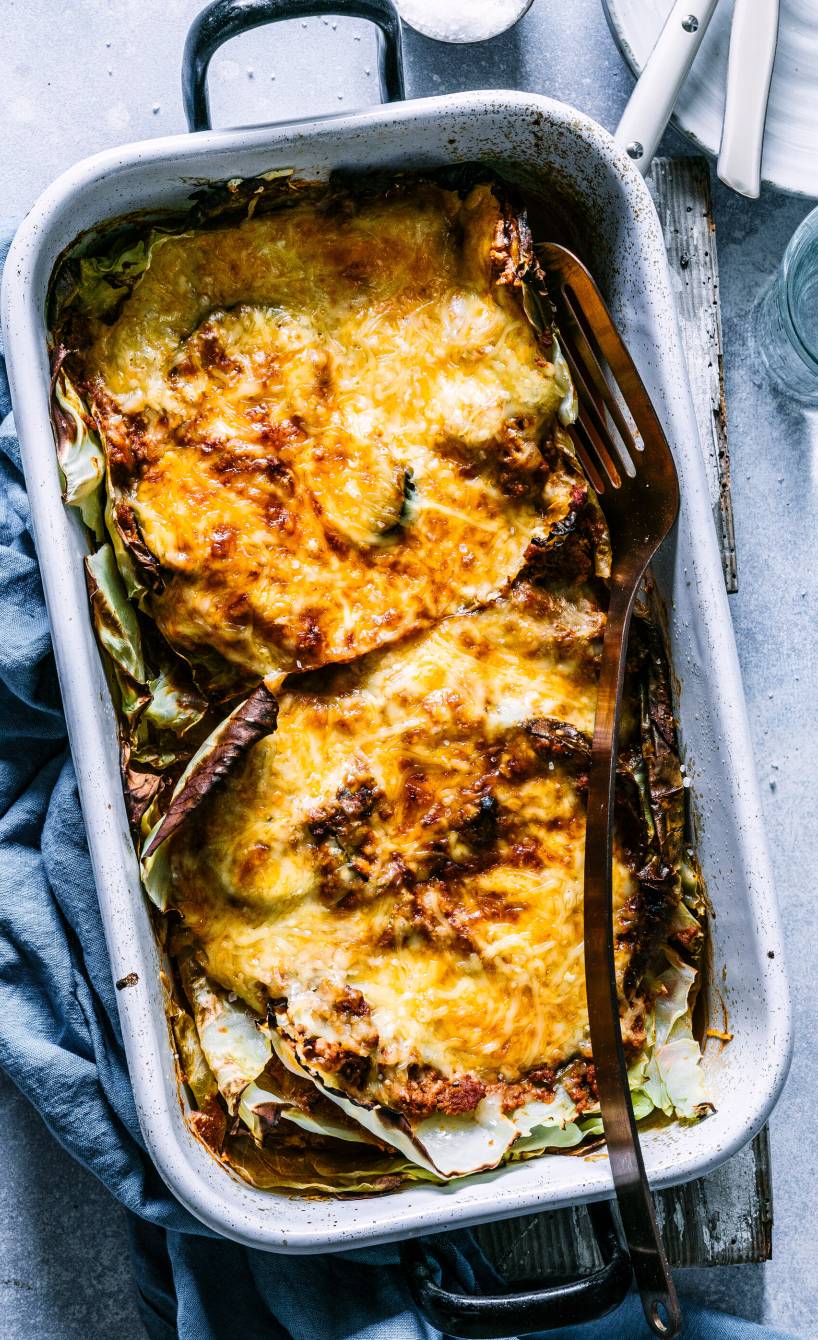 Low-Carb-Lasagne mit Käsedecke angeschnitten in einer Auflaufform von oben auf einem Tisch
