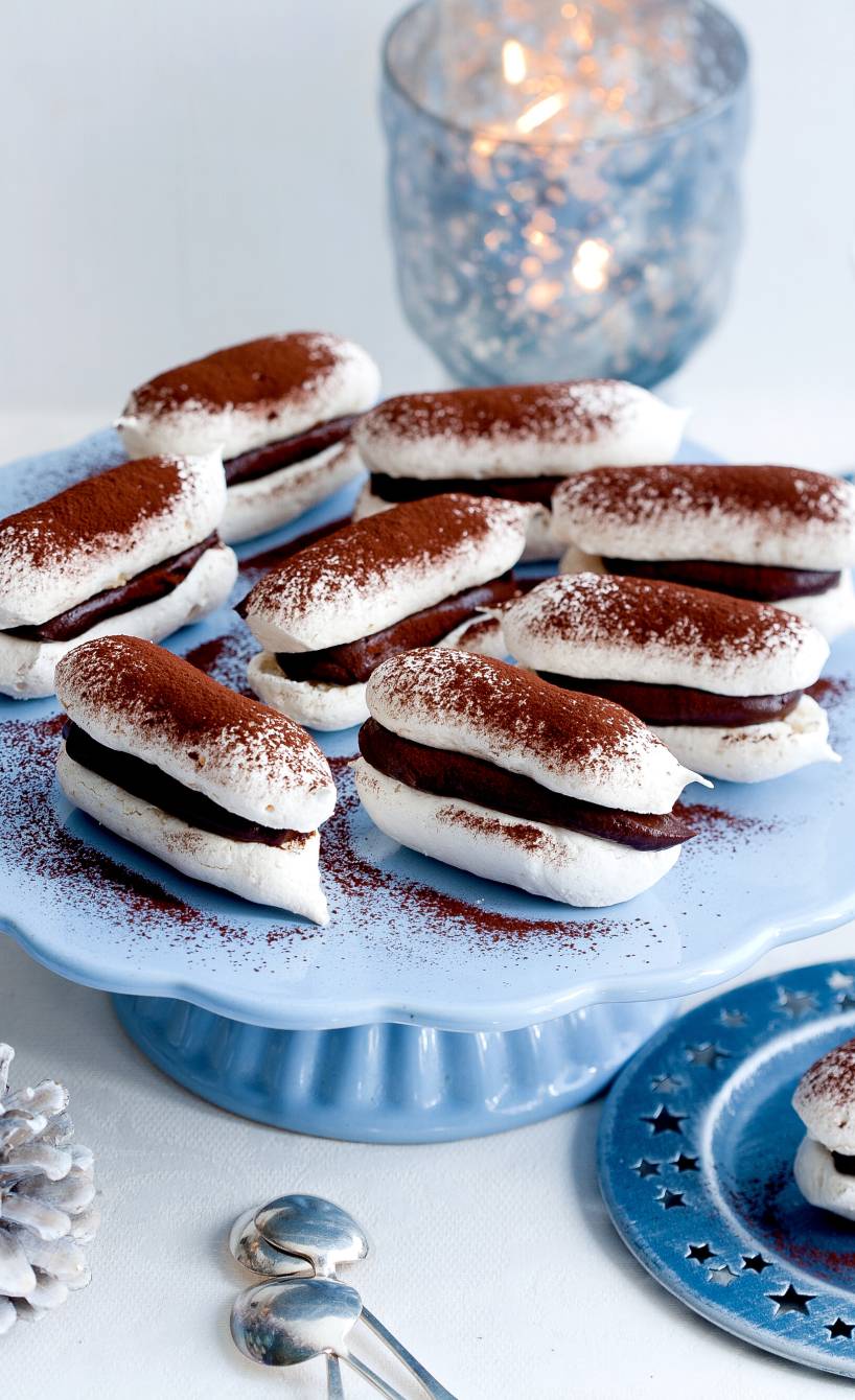 Doppeldecker-Baiser-Plätzchen mit Mandeln und Schokoladenfüllung auf einer Tortenplatte