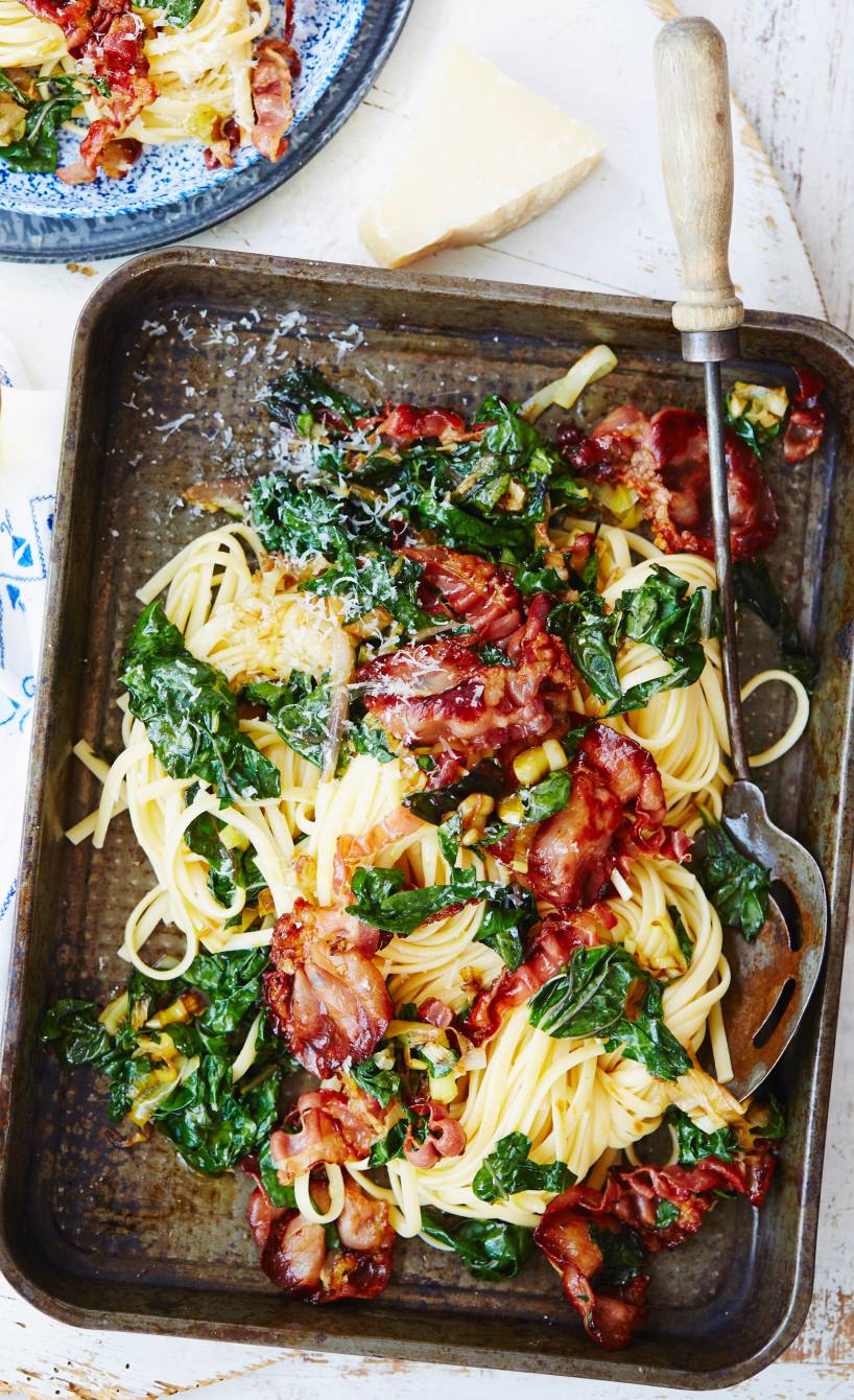Linguine mit Mangold und knusprigem Pancetta in einer rechteckigen Pfanne auf einem Tisch