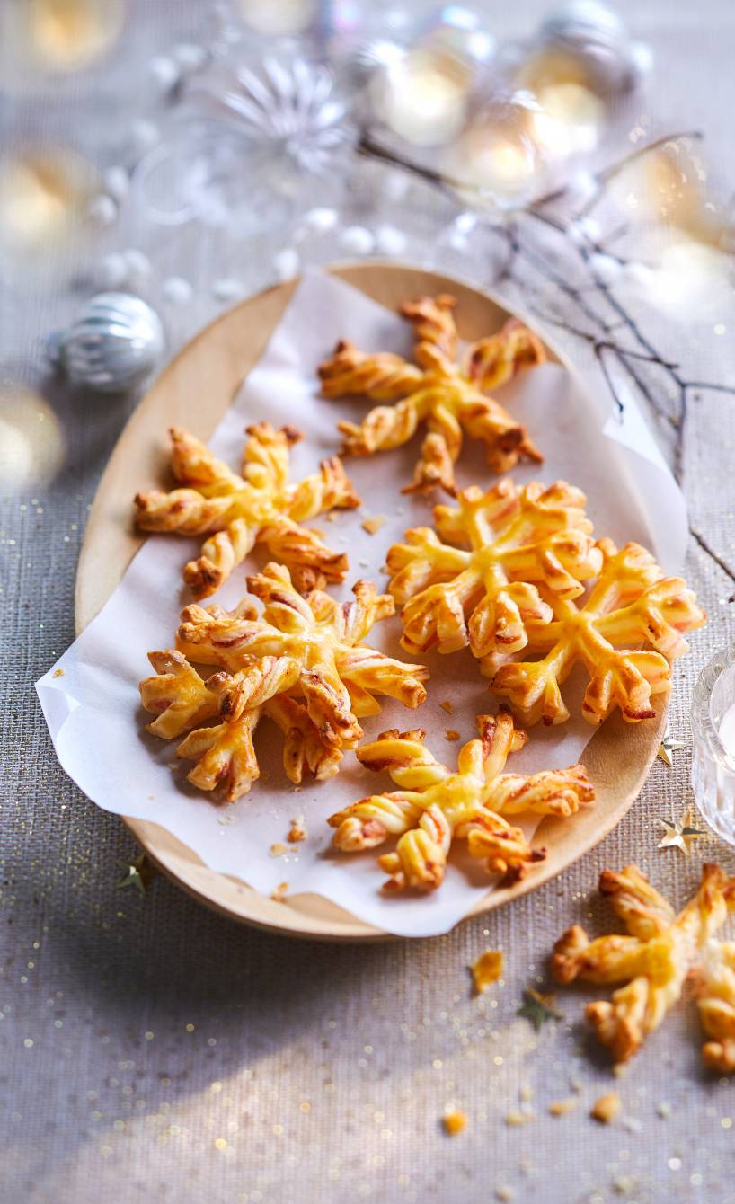Selbstgebackene Schneeflocken-Plätzchen aus Blätterteig auf einem Plätzchenteller