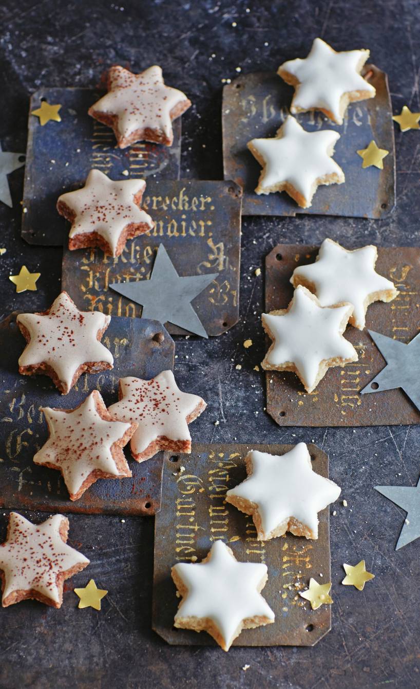 Selbstgebackene Marzipan-Nuss-Plätzchen in Sternform mit Glasur auf weihnachtlichen Karten