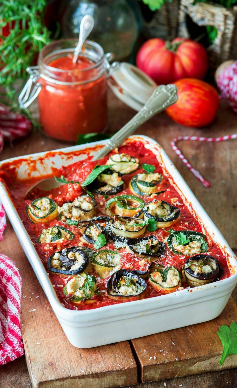 Mit Feta gefüllte, gebackene Zucchini- und Auberginenröllchen in Tomatensoße