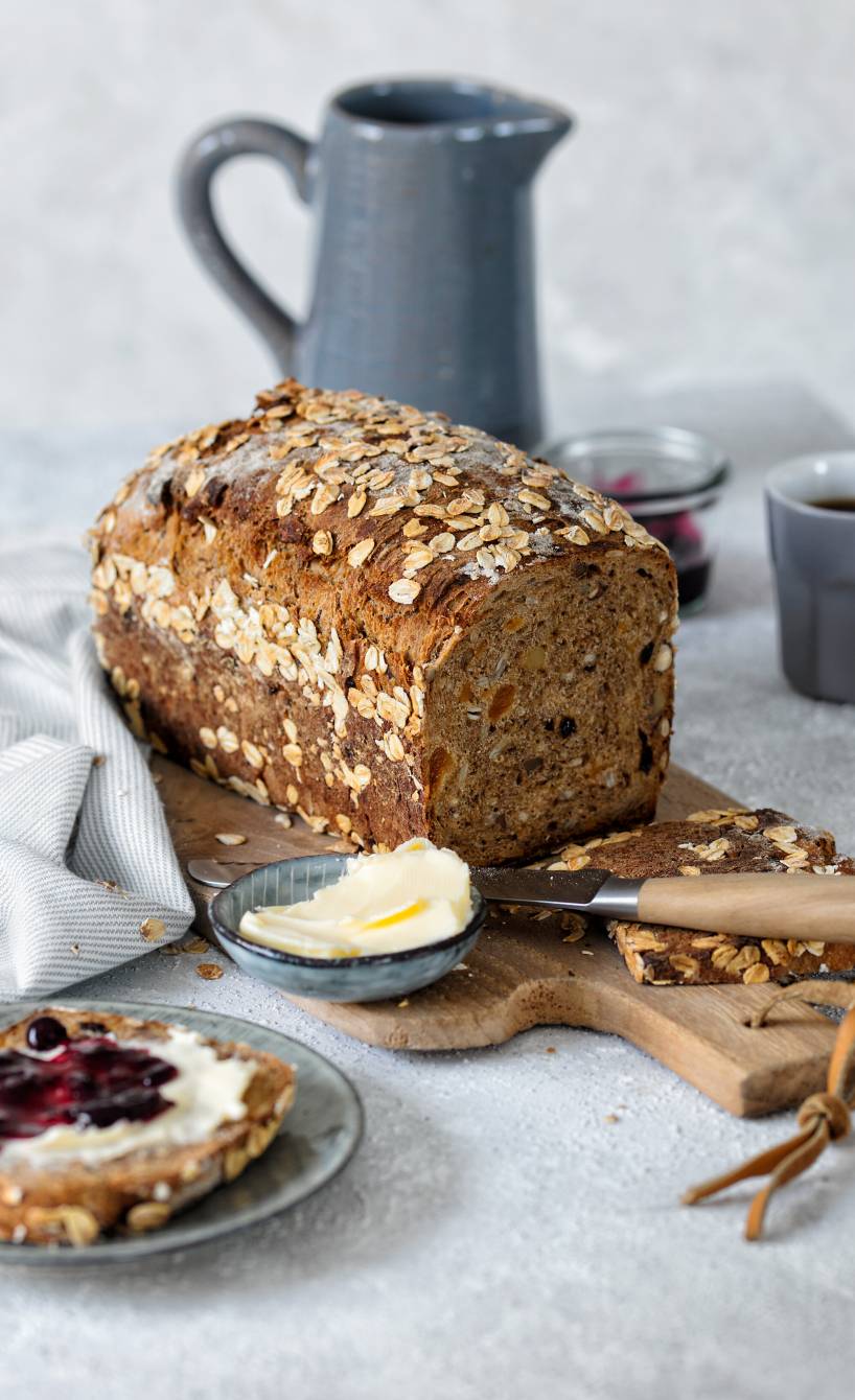 Selbstgebackenes Müslibrot mit Haferflocken angeschnitten auf einem Holzbrett