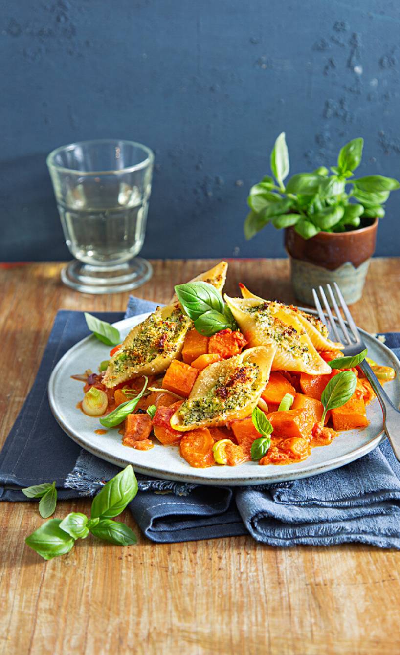 Riesige, gefüllte Muschelnudeln angerichtet auf einem Teller mit Kürbis-Gemüseragout
