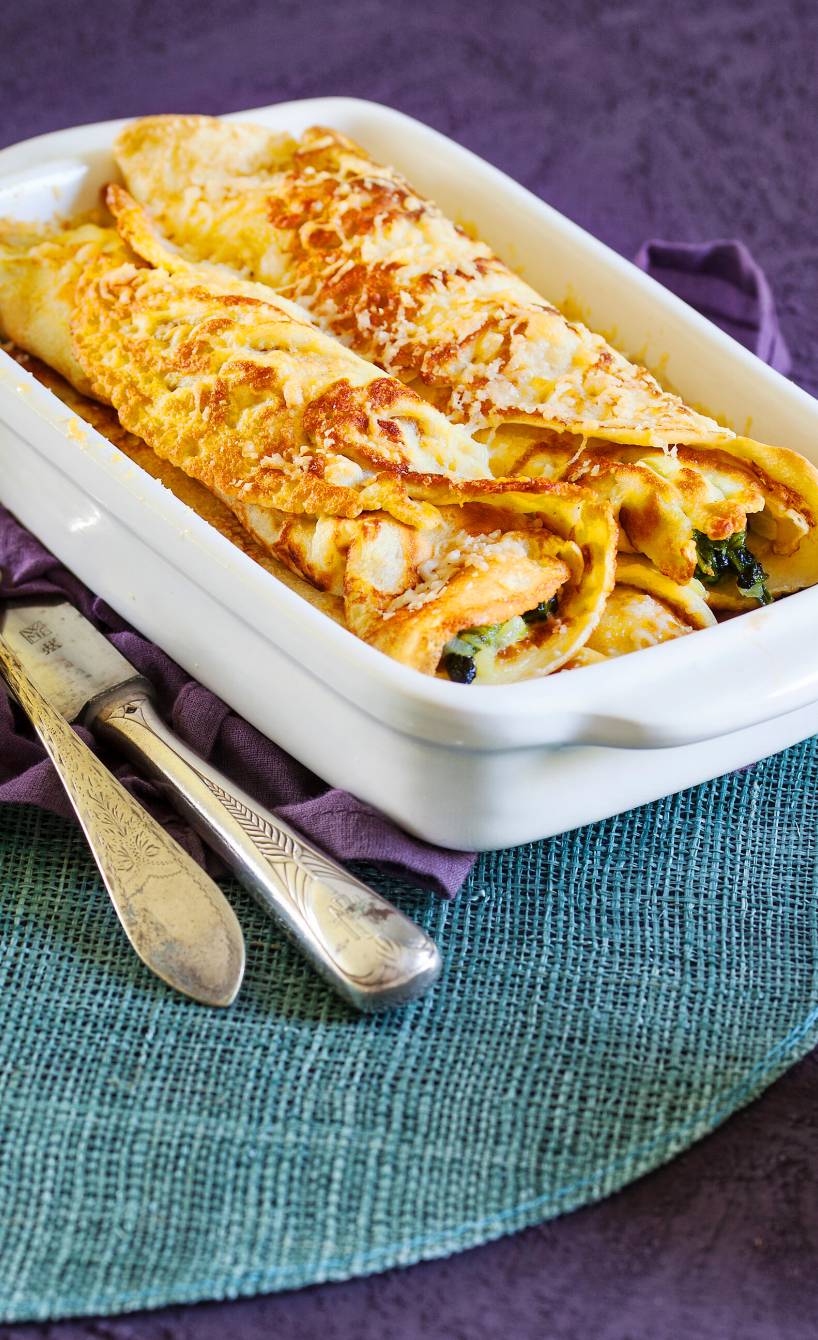 Ofenpfannkuchen in einer Auflaufform gefüllt mit Spinat und Gorgonzola