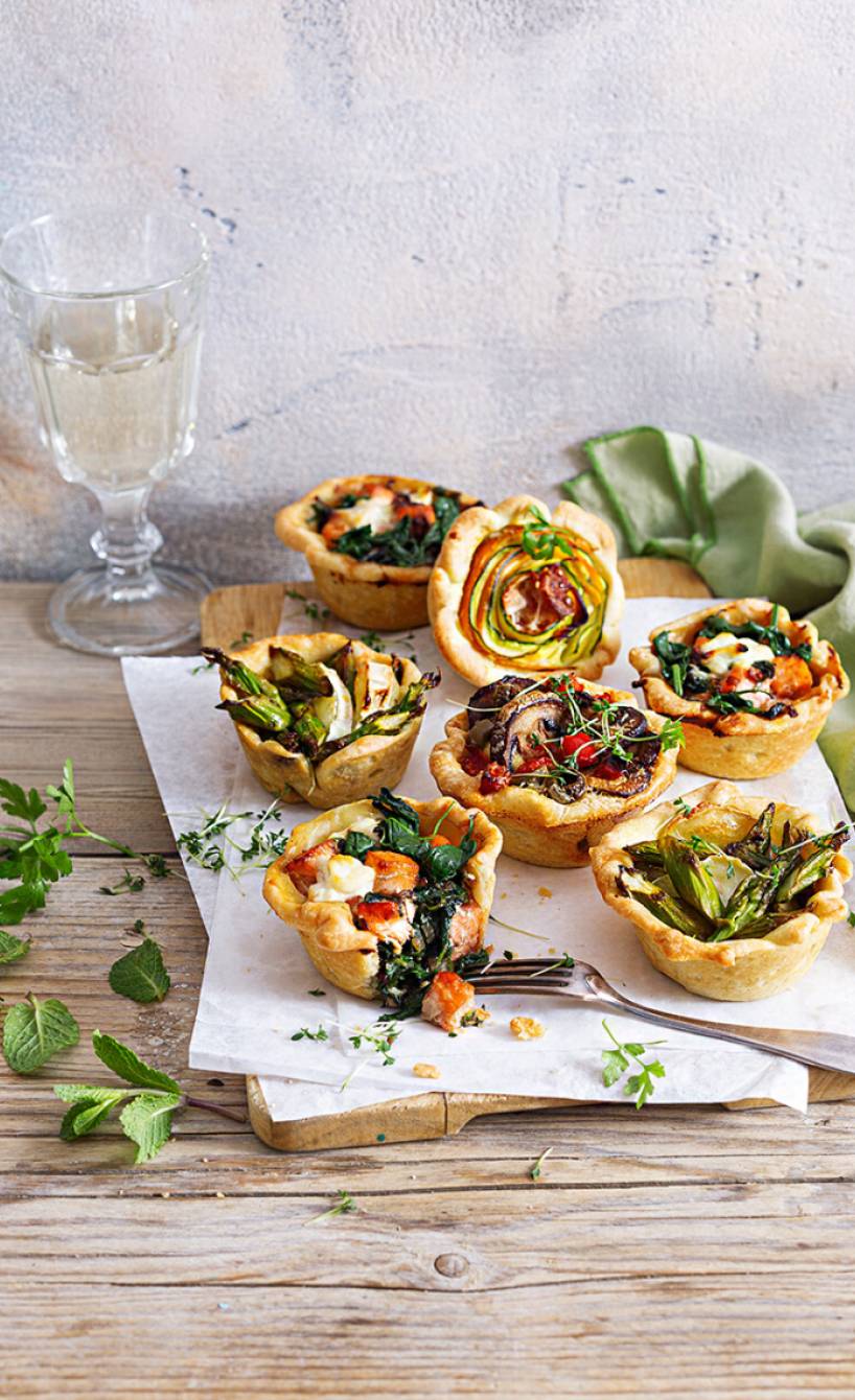 Ostermuffins mit verschiedenen herzhaften Füllungen auf einem Holzbrett