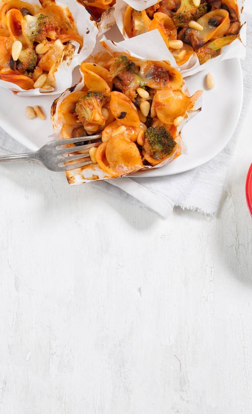 Vier Nudelmuffins mit Pilzen und Brokkoli auf einem Teller